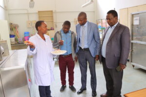 Hon. Ogindo and Eng. Onyango learn how the two-screw laboratory food extruder works at JKUAT
